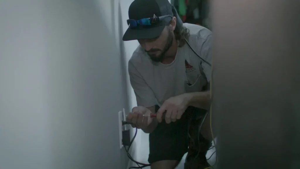 A man fixing an electrical outlet.