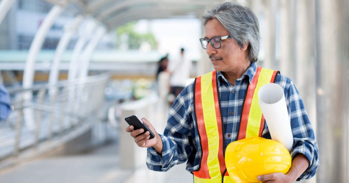 picture of man in construction gear on cell phone