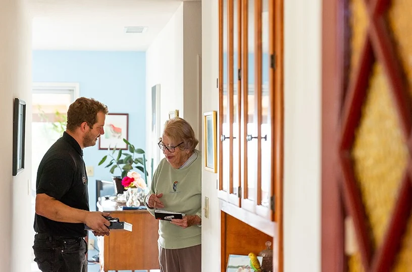 Male pro getting signature from elderly female customer