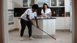 two female home cleaning pros at work in kitchen