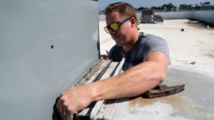 Man working on hvac unit on top of a building
