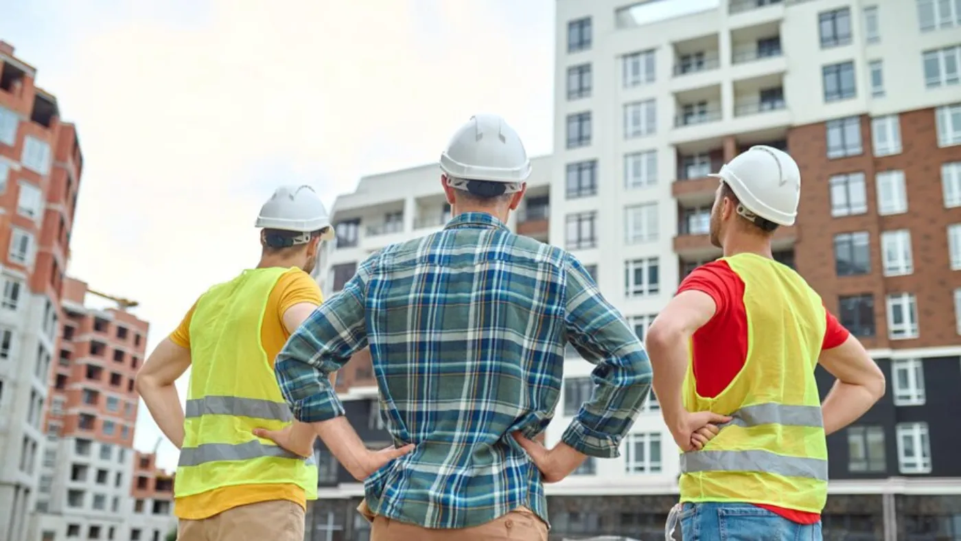 Contractors overlooking a building