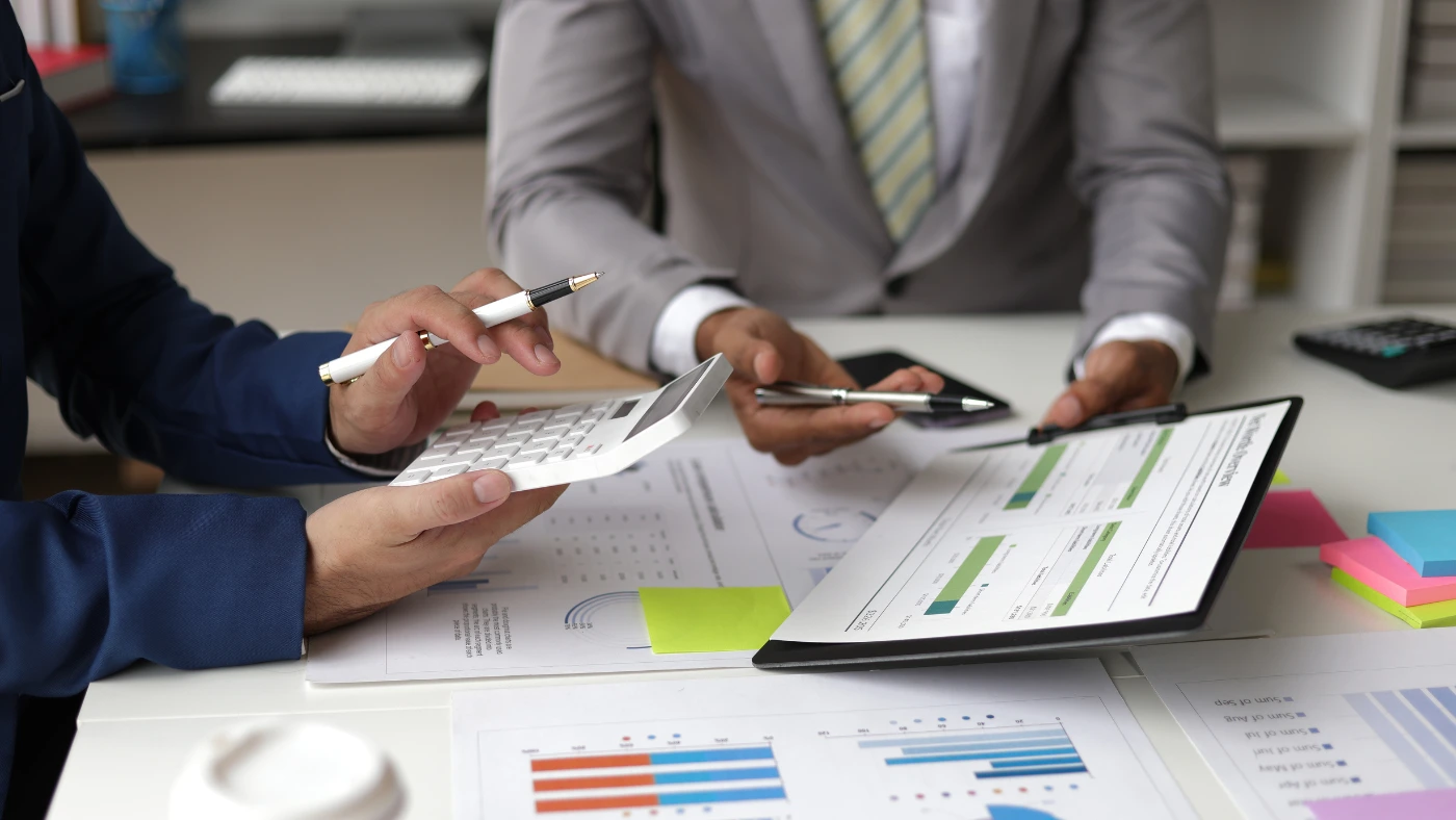 Pros working in an office, discussing and analyzing reports.