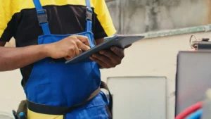 close up of skillful technician commissioned outside for hvac system routine maintenance looking at refrigerant issues using a tablet