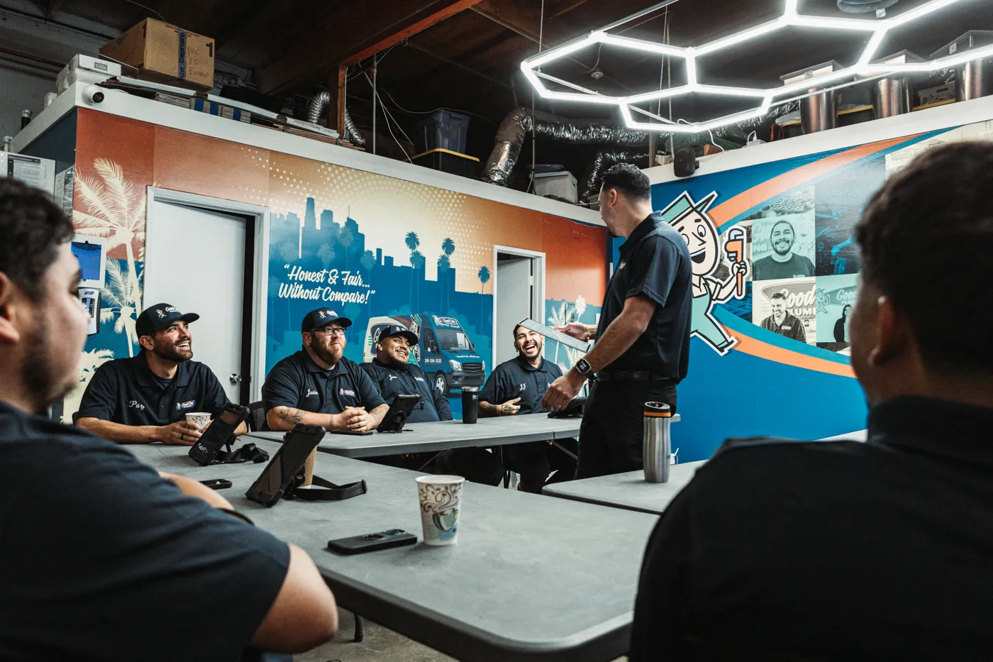 Professional plumbing team gathered for a team meeting focused on training and communication.