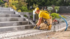 Pro worker laying cobblestones for a garden pathway in a landscaped area